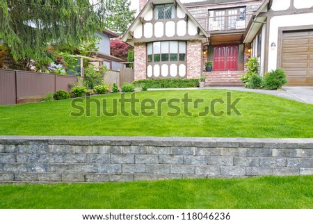 Nicely trimmed lawn on the leveled front yard. Landscape design.