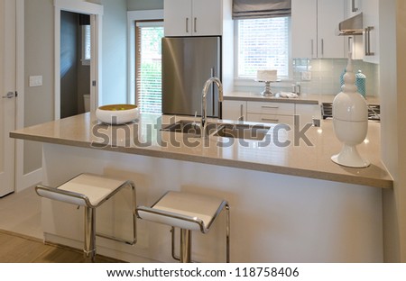 Interior design of a luxury modern kitchen with two sits and the dish with some pears on the counter. I