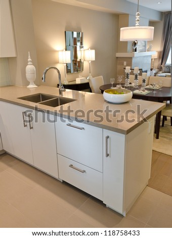 Interior Design Of A Luxury Modern Kitchen With The Dish With Some Pears On The Counter And The Dining Room At The Back.. I