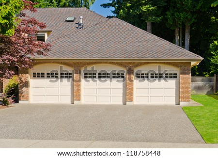Triple doors garage with wide long driveway.