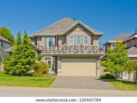 Big custom made with double doors garage luxury house and nicely landscaped front yard in the suburbs of Vancouver, Canada.