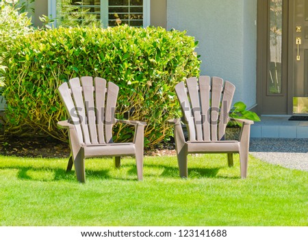 Two lawn chairs at the front ( back ) yard.