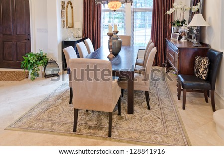 Nicely decorated  living ( lunch ) room. Dining table and some chairs.