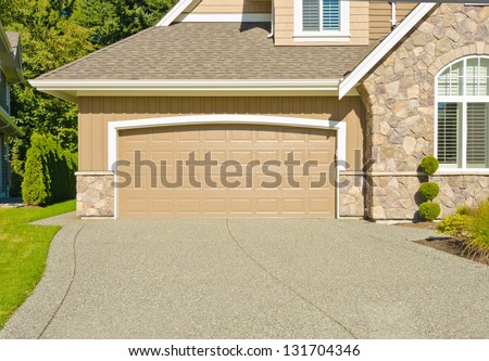 Double doors garage with wide and long driveway. North America.