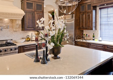 Fragment of a luxury modern kitchen. Some flowers, bouquet in the vase on the counter. Interior design.