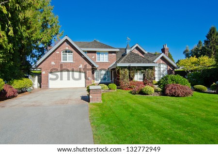 Big custom made luxury house with nicely paved driveway and triple doors garage in the suburbs of Vancouver, Canada.