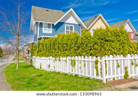 County style wooden fence with some bushes growing through it.