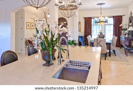 Interior design of a luxury modern kitchen with the vase with some flowers on the counter. Vertical.