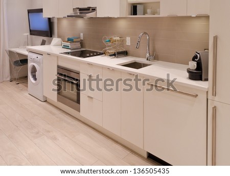 Interior design of a modern kitchen, in combination with laundry and the office room. For small condos.