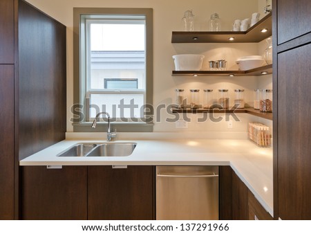Fragment Of The Luxury Modern Kitchen With Some Shelves With Jars, Cans In The Corner And Window Atop Of The Sink. Interior Design.