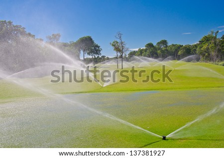 Mexican resort golf course gets irrigated. Golf field, course sprinkling.