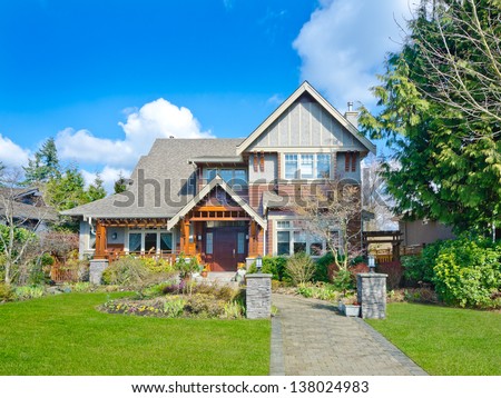 Big custom made luxury house with nicely paved long doorway and trimmed front yard in the suburbs of Vancouver, Canada.