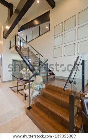 Fragment of the luxury spacious modern room with the stairs to the upper level. Interior design. Vertical.