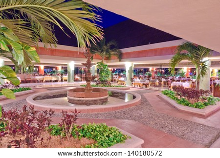 Interior of the luxury caribbean restaurant with the fountain in the middle  at night, dawn time. Bahia Principe, Mexican Resort.