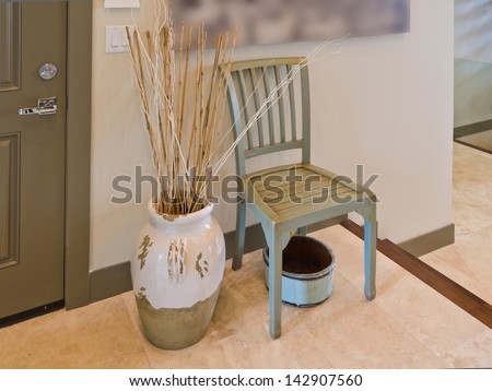 A chair and the vase in the room, hall, lobby.  Decorative fragment. Interior design.