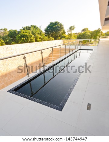 Perspective of the modern glass and steel balcony, deck, promenade railing and the water pool as an decor design. Exterior, interior design.