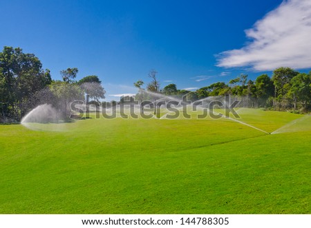 Golf course gets irrigated. Golf field, course sprinkling.  Mexican resort. Bahia Principe, Riviera Maya.