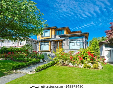 Big custom made luxury house with nicely landscaped front yard lawn in the suburbs of Vancouver, Canada.