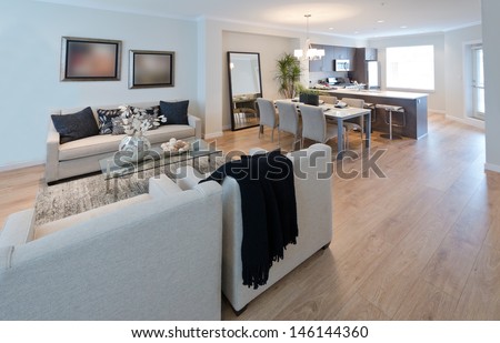 Family, living room with dining table and the luxury modern kitchen at the back. Interior design.