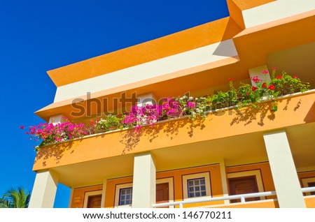 Fragment of the colorful luxury caribbean resort hotel building. Balcony with some flowers.  Bahia Principe, Riviera Maya.