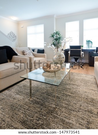 Luxury living suite. Living, family room with the decorative vase on the glass coffee table and the couch and pillows. Interior design.  Vertical.