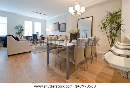 Luxury living suite. Dining room with the coffee set on the table and the living, family room at the back. Interior design.