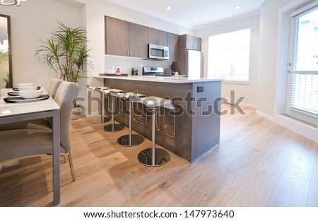 Interior design of a luxury modern kitchen with the nicely decorated and served living, lunch room table with the coffee, tea set. Interior design.