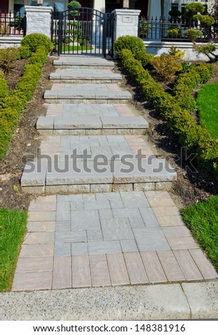 Nicely paved and stoned doorway and trimmed bushes  Landscape design.