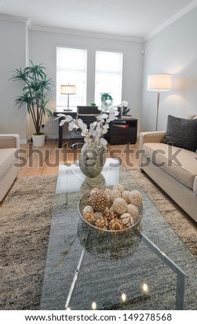 Decorative vase on the coffee table in the living room with the office table at the back. Interior design. Vertical.