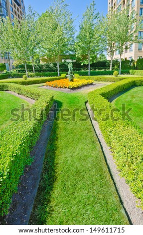 Landscape design. Nicely trimmed bushes and flowerbed in the park. Vancouver. Canada. Vertical.