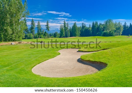 Sand bunker at the beautiful golf course with a mountains and dark blue sky. Vancouver, Canada.