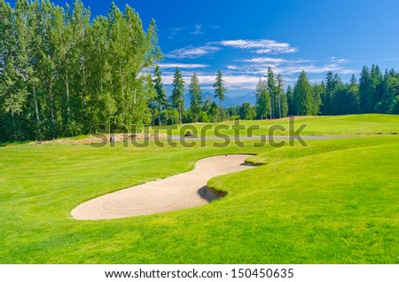 Sand bunker at the beautiful golf course with a mountains and dark blue sky. Vancouver, Canada.