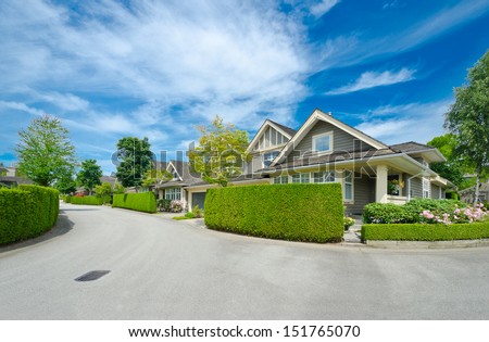 Nice And Comfortable Neighborhood. Houses Behind Nicely Trimmed Green Fence On The Empty Street In The Suburbs Of Vancouver, Canada. Landscape Design.