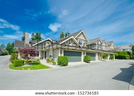 Nice neighborhood. Houses with double doors garages on the corner of empty street in the suburbs of Vancouver, Canada.