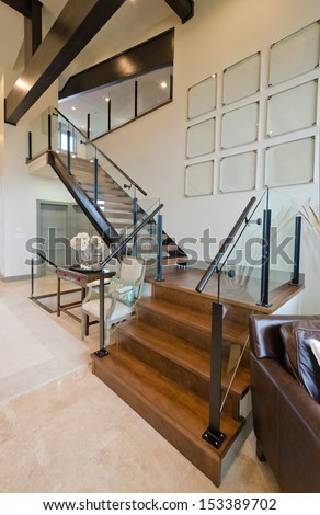 Fragment of the luxury spacious modern room with the stairs to the upper level. Interior design. Vertical.