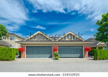 Two double doors garages decorated with flower buckets in the suburbs of Vancouver, Canada.