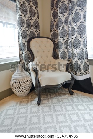 A chair and a decorative vase in the corner of the room. Fragment. Interior design. Vertical.
