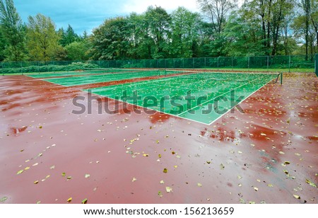 End of the season at tennis court covered with the leafs at autumn, fall time. Rainy day.