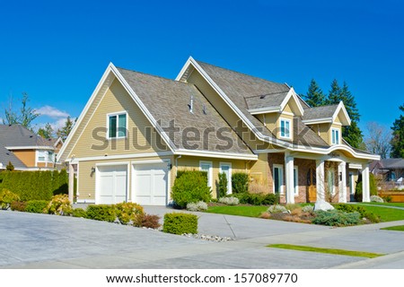 Big custom made luxury house with double doors garage and nicely trimmed and landscaped front yard lawn in the suburbs of Vancouver, Canada.