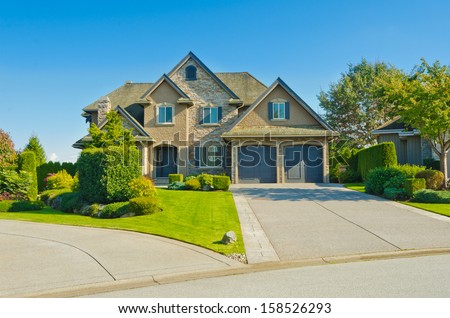 Big custom made luxury house with double garage doors and long driveway in the suburbs of Vancouver, Canada.