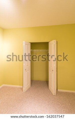 Empty room in a modern house with the open closet, cabinet doors. Interior design.