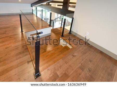 Hardwood Floor And Stairs, Entrance To The Luxury Upper Home Level With The Spacious Living Room Downstairs. View From Atop. Interior Design.