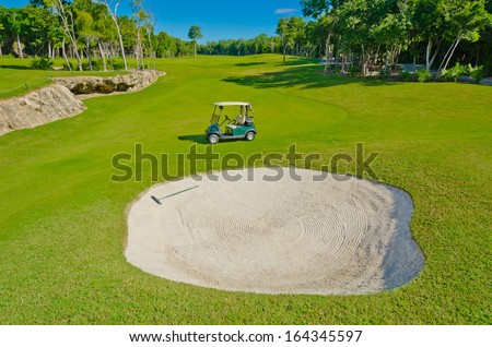 Panorama, outlook at the beautiful golf course with the golf cart at the sand bunker. Luxury mexican resort.