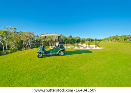 Panorama, outlook at the beautiful golf course with the golf cart at the sand bunkers. Luxury mexican resort.