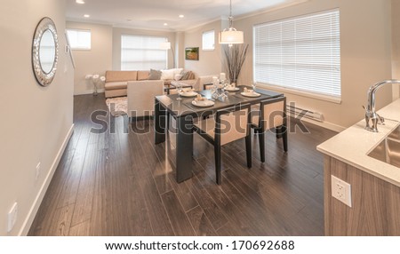Outlook, panorama at the luxury and nicely decorated modern living set, lunch room with the decorated table with the dinner set and the kitchen aside . Interior design of a brand new townhouse.