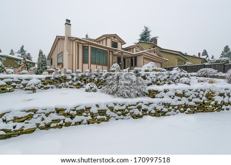Big luxury house in snowfall cold, chilly and frosty winter time, covered with snow. Vancouver, Canada.