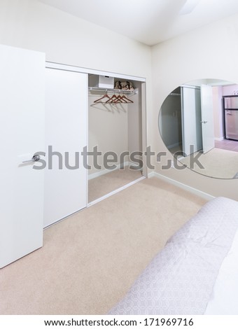 Room, bedroom with the open empty closet, working closet, cupboard with some racks, hangers and big mirror. Interior design.