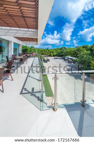 Perspective, Outlook At The Modern Stylish Balcony, Deck, Patio Of The Restaurant, Cafe, Bar With Glass And Steel Railing. Luxury Mexican Resort. Exterior, Interior Design.