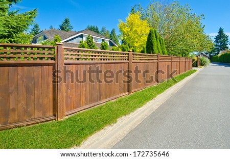 Long wooden cedar fence on the empty street.
