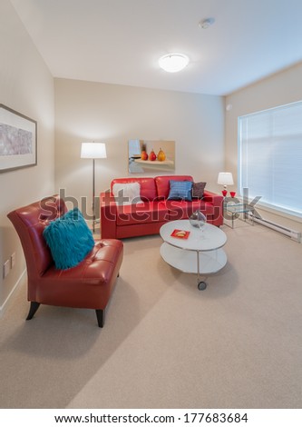 Luxury living suite of brand new townhouse. Nicely decorated modern family, living room with red color leather couch, chair and coffee table. Interior design. Vertical.